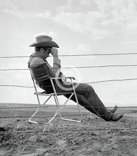 James Dean Seated Behind Fence On The Set Of Giant